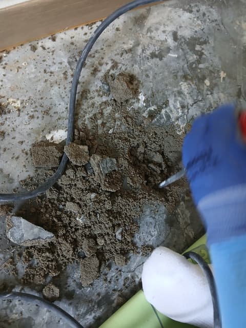 상가주택 수도배관 누수 공사 - 새는 자리 위 바닥을 깨어 내는 모습